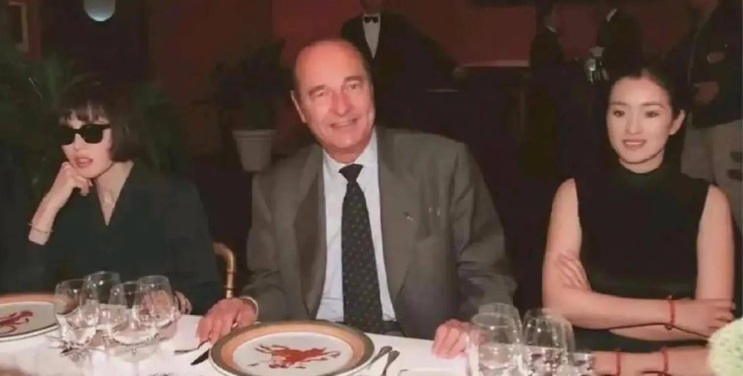 巩俐陪马克龙夫妇吃烤鸭!穿黑衣扎丸子头气场强,没戴华丽首饰很低调,曾多次跟随马克龙访华