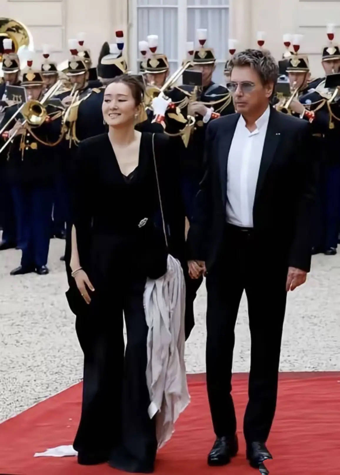 巩俐陪马克龙夫妇吃烤鸭，穿黑衣扎丸子头气场强，快六十岁还很美