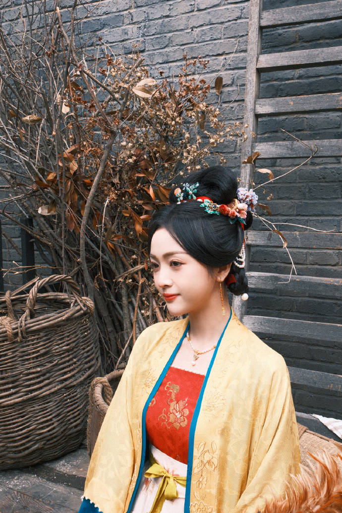 吴宣仪一袭淡黄色汉服抬头望花清丽动人