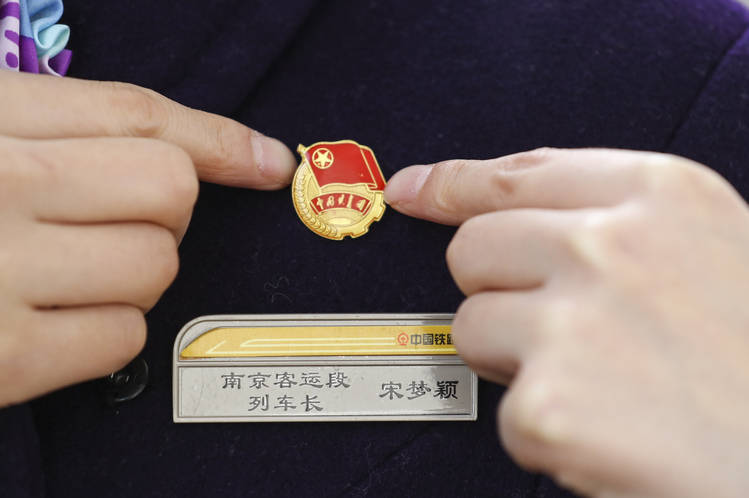 2024年2月6日,d9577次列车长宋梦颖在江苏宿迁站出发前整理团徽