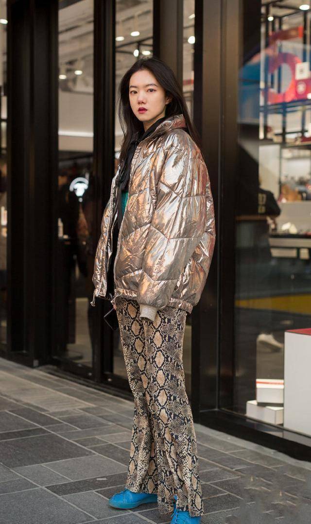 寒冷的季节需要一些多姿多彩的色彩加以装饰,镭射羽绒服搭配豹纹长裤