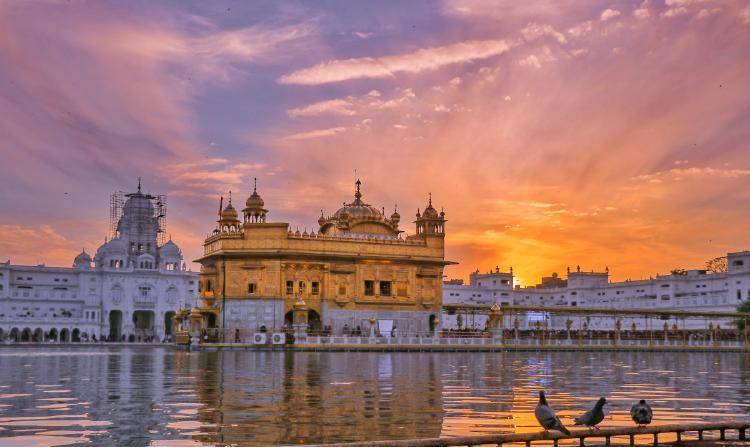 金碧辉煌的阿姆利则金庙和背后的"永恒王座"宾德兰瓦里占据金庙及其