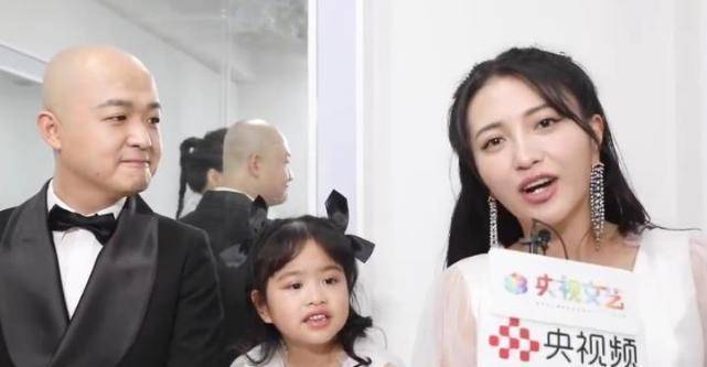 包贝尔和老婆都倚靠着化妆桌,而女儿包饺子坐在化妆台上面,一家三口
