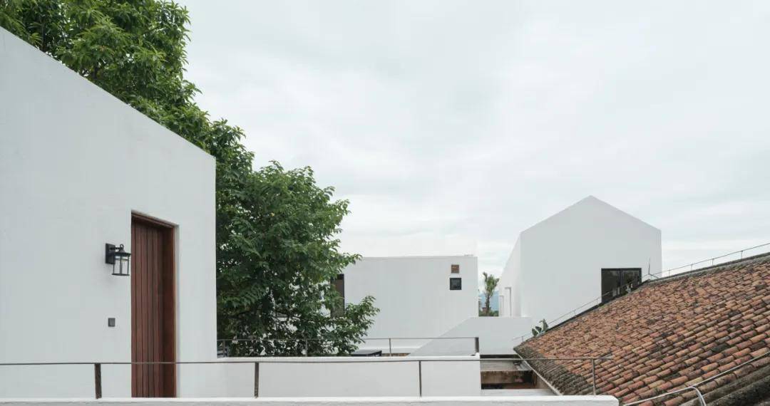 "左边这间青砖屋是我大哥的,也有上百年历史了,右边这个石凳,我们从小