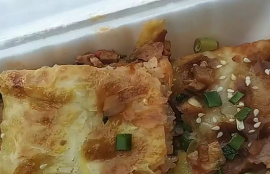 武汉最有名三鲜豆皮小吃用糯米和面糊摊在锅里顾客排队买