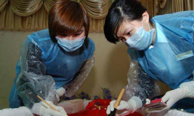 一般由女性担任,出于对死者的尊敬,在为死者收敛妆容时一般身着红裙