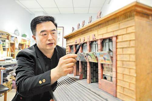 4月26日,衡水微缩模型手艺人王伟在清理他制作的衡水红旗影剧院模型