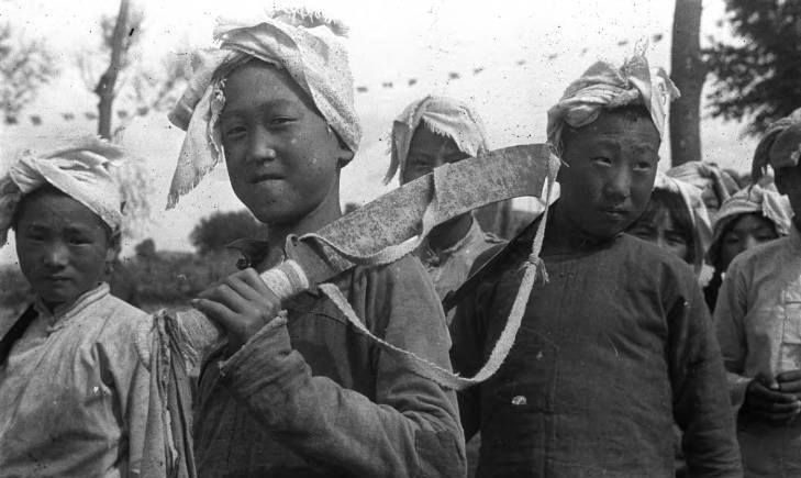 图:抗战时期民兵们的经典装扮,手持步枪,腰带上插着大刀.