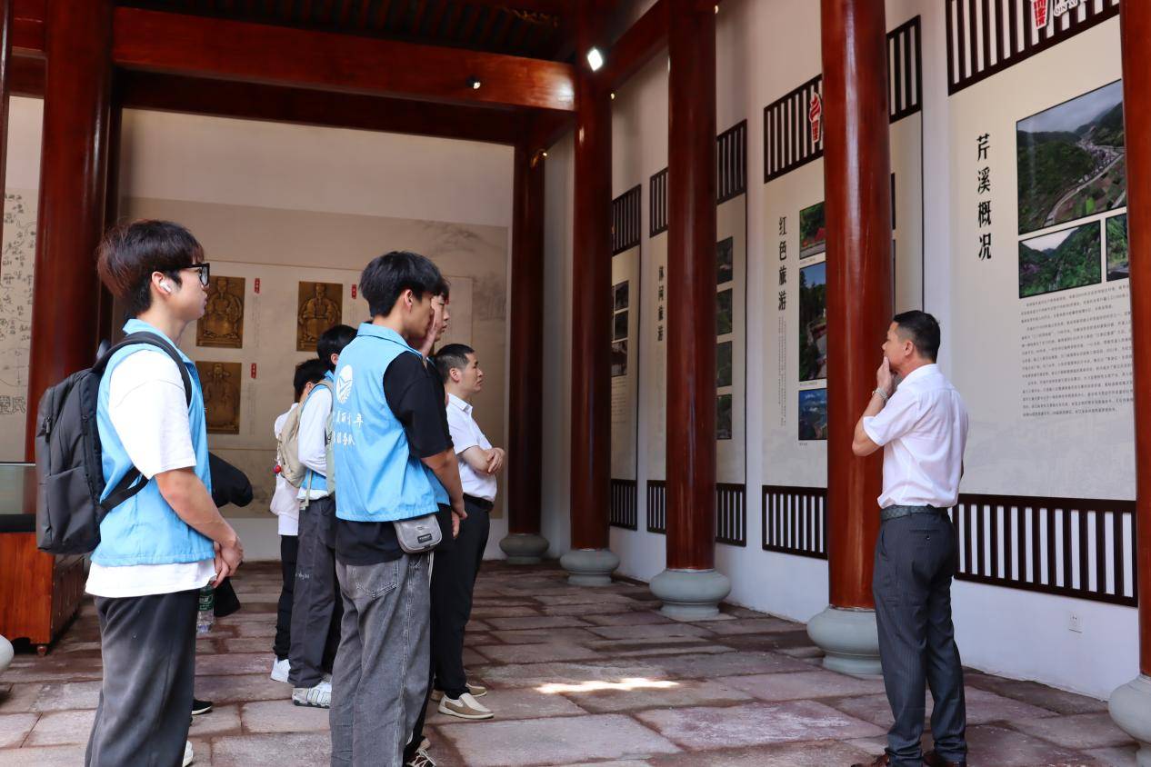 图3为卢书记向实践团讲述芹溪村的发展历程与现状传