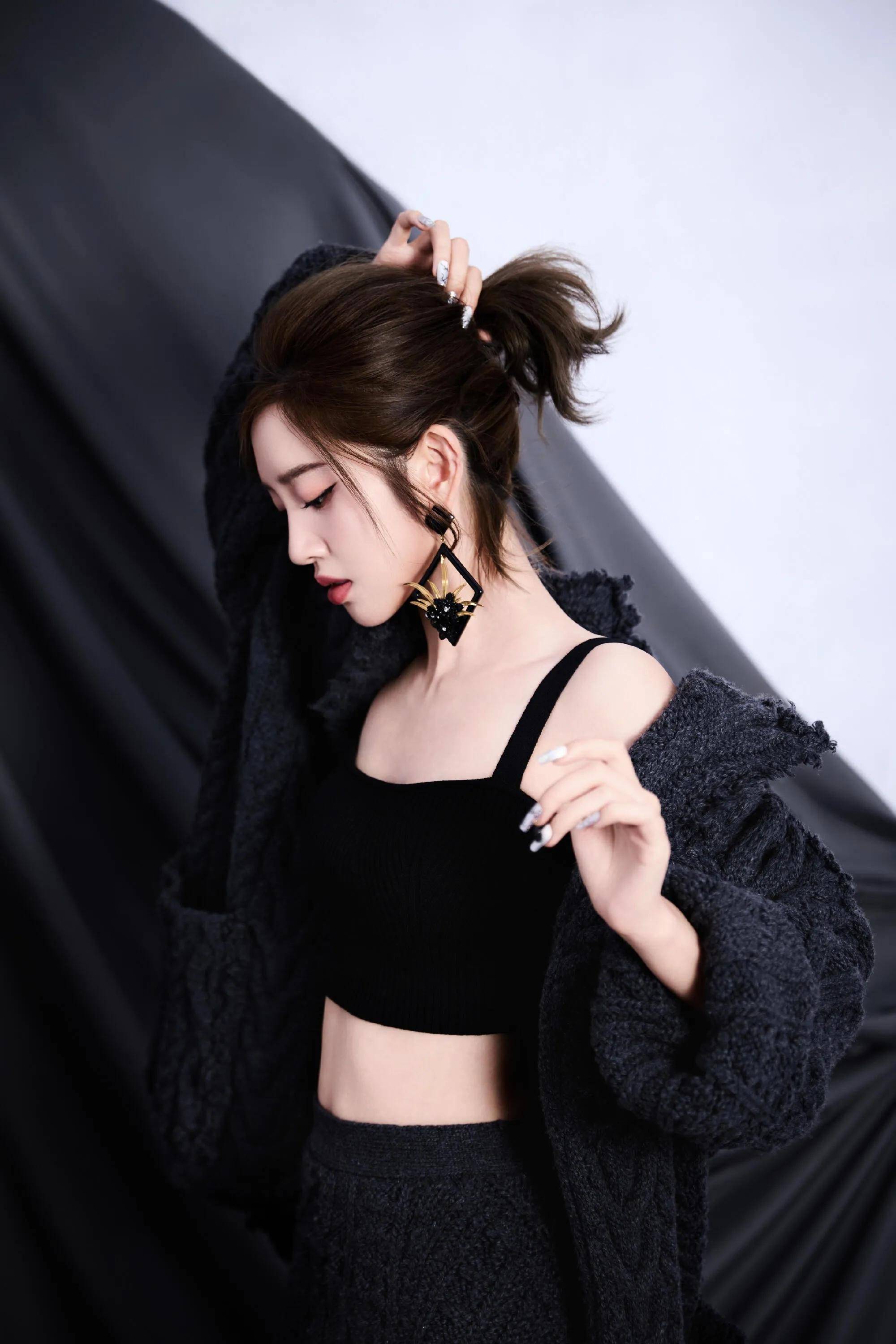 黑色吊带与耳饰的搭配简洁优雅,手部美甲细节与整体造型呼应,精致感从