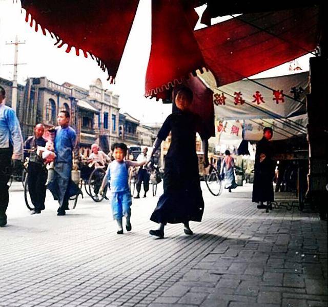 1939年夏天的北京前門,母女坐地休息納涼,男孩吃冰棍