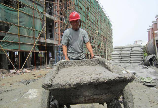 王烽谷和儿子每年都会来到福建漳州的工地上搬砖,扛水泥