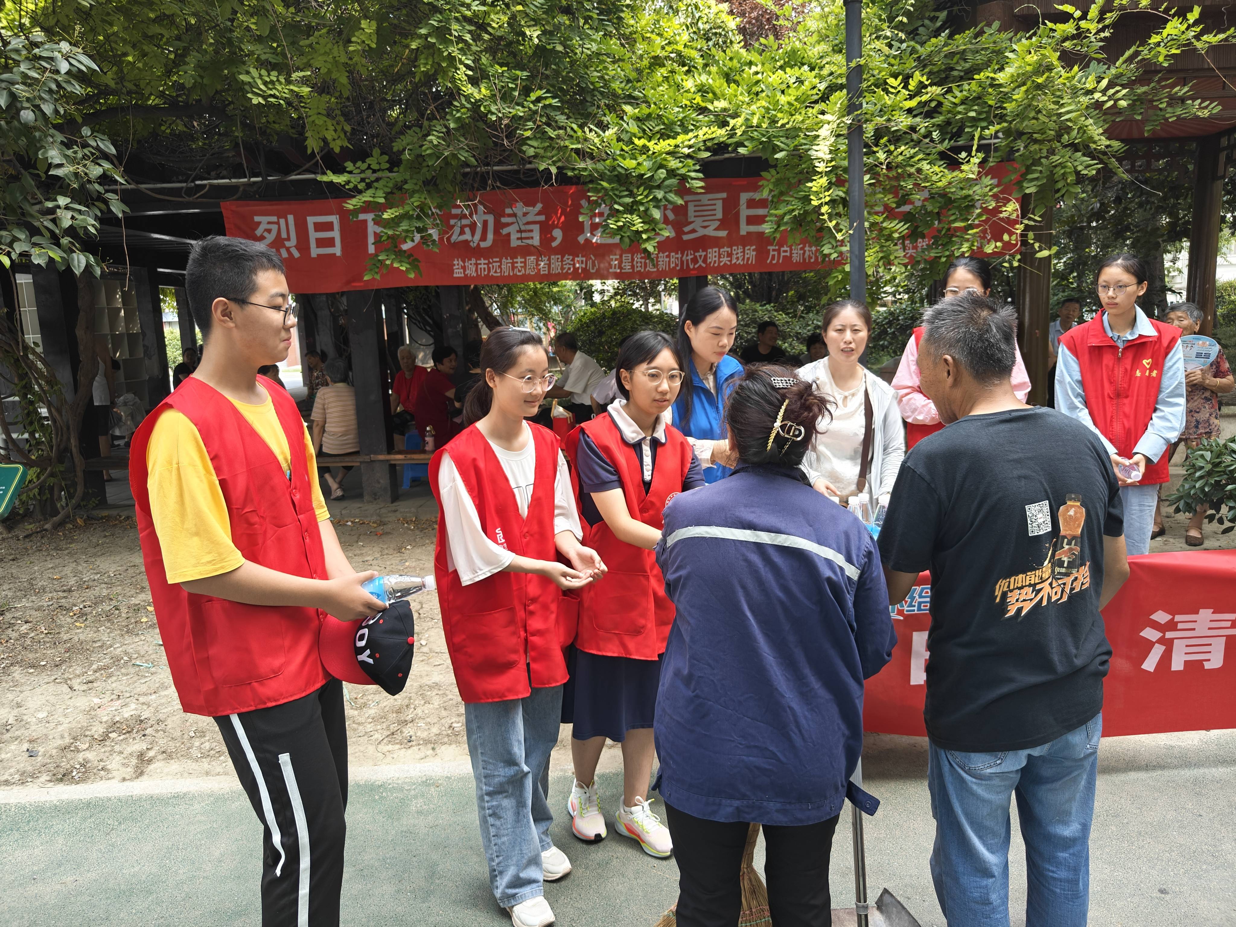 活动中,网格员,志愿者忙碌而有序地分发着清凉物资,他们将矿泉水,帽子