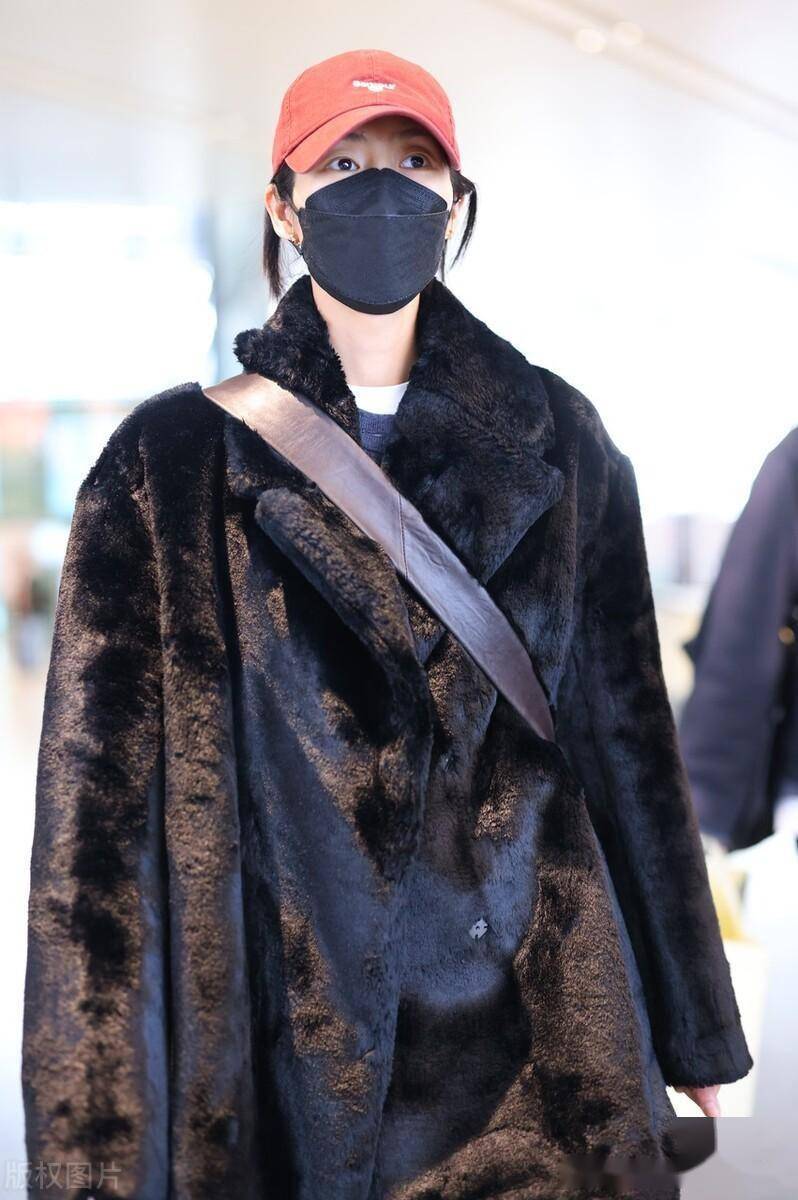 街拍:刘雯黑色皮草外套 牛仔裤 皮鞋 斜挎包 红色棒球帽时尚休闲