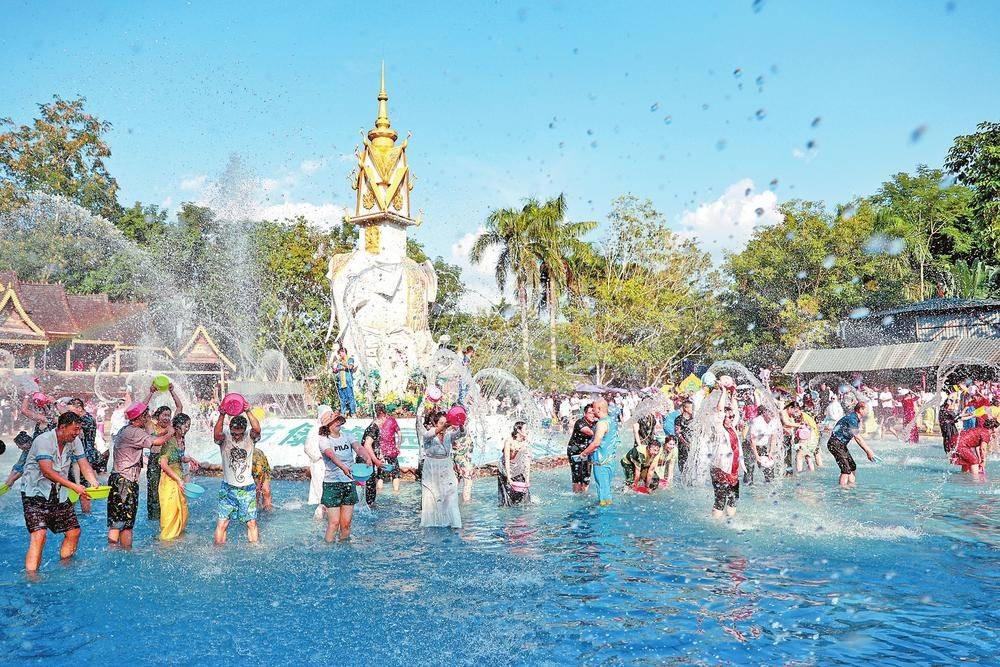图为游客在西双版纳傣族园泼水广场纵享天天欢度泼水节