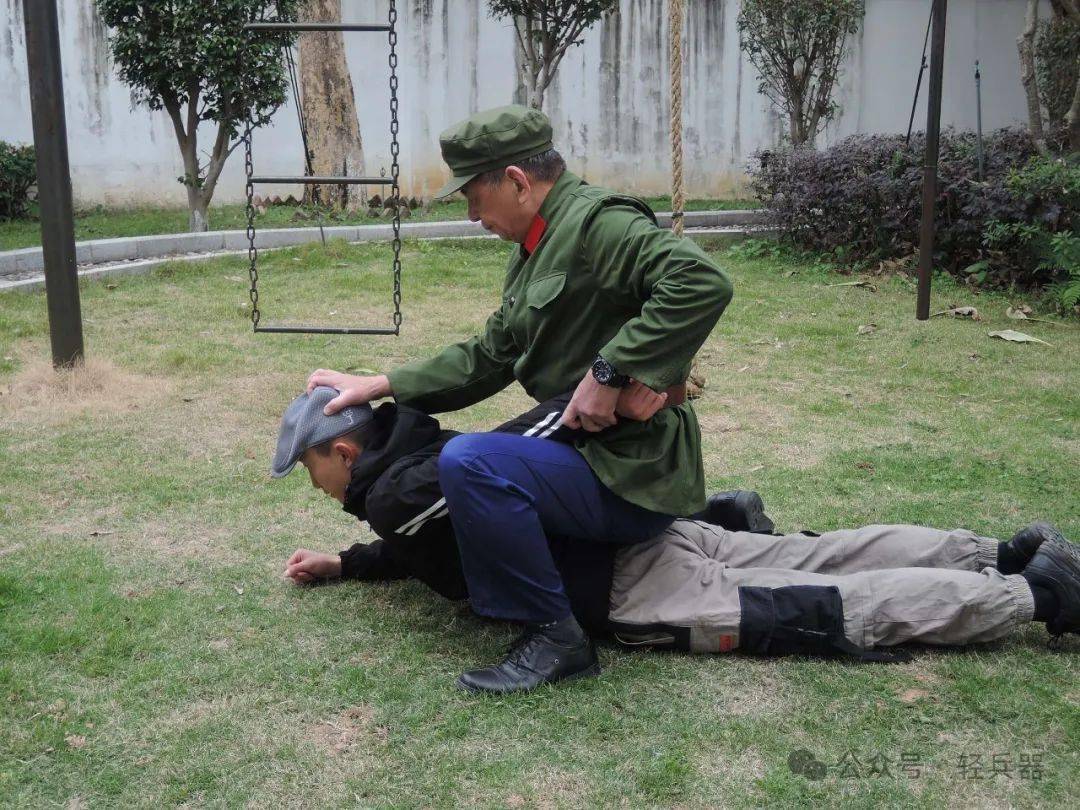 换手抓发,以同样方法控制敌另一臂,两腿挟住敌双肘时,即可进行捆绑(注