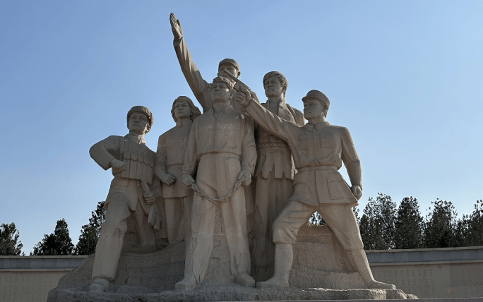 雕塑后面的英烈墙全长55米,左右两侧的"解放军渡江""群众支援前线"