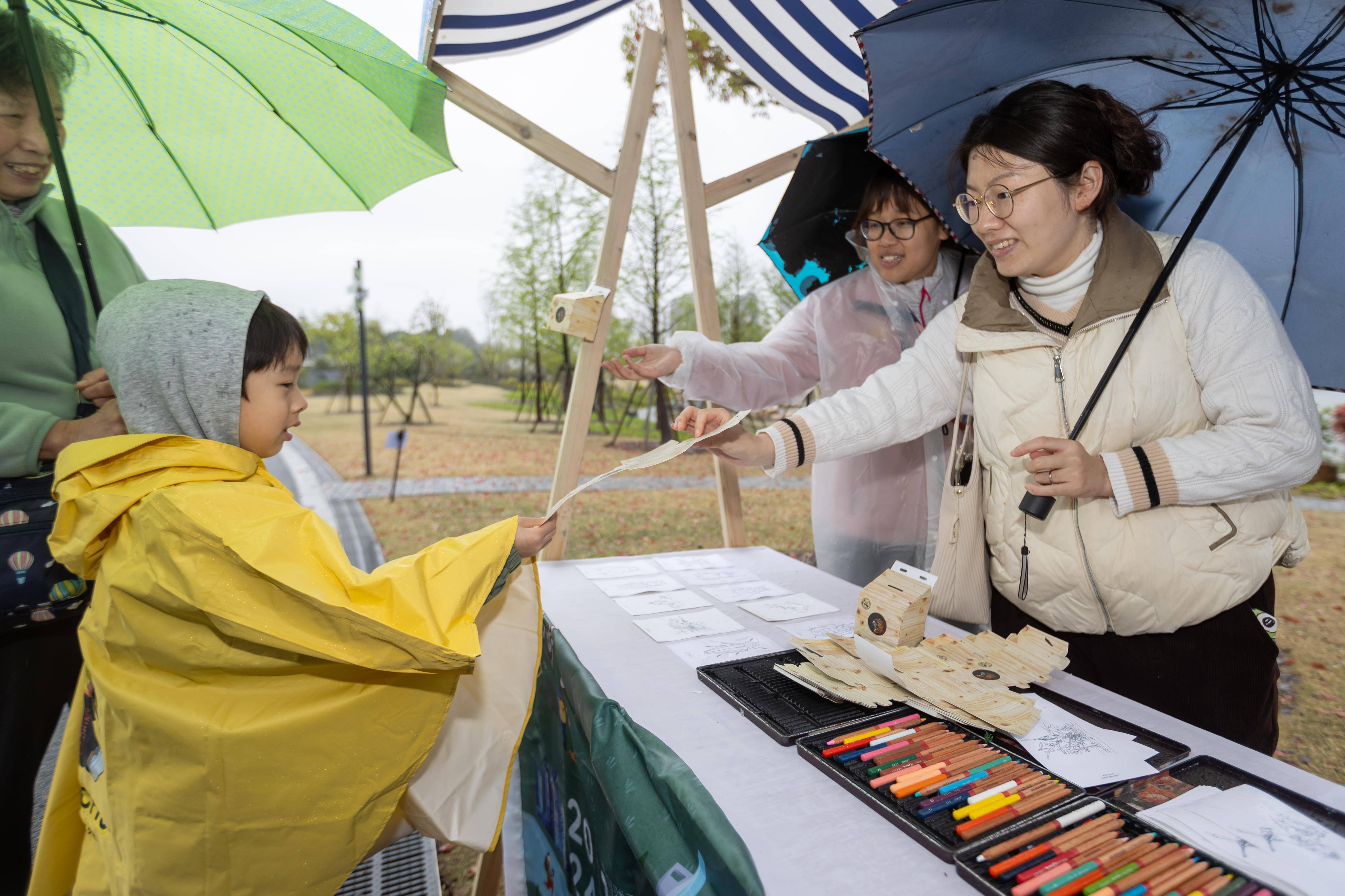 4月8日,一名小朋友在"爱鸟助飞"公益市集领取制作"鸟巢"的折纸.