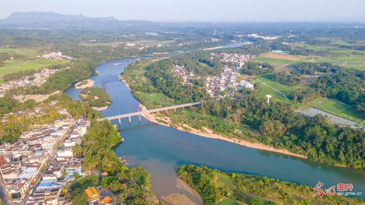 2024年3月31日,海南省琼海市春光下的万泉河石壁(左),龙江镇两岸春色