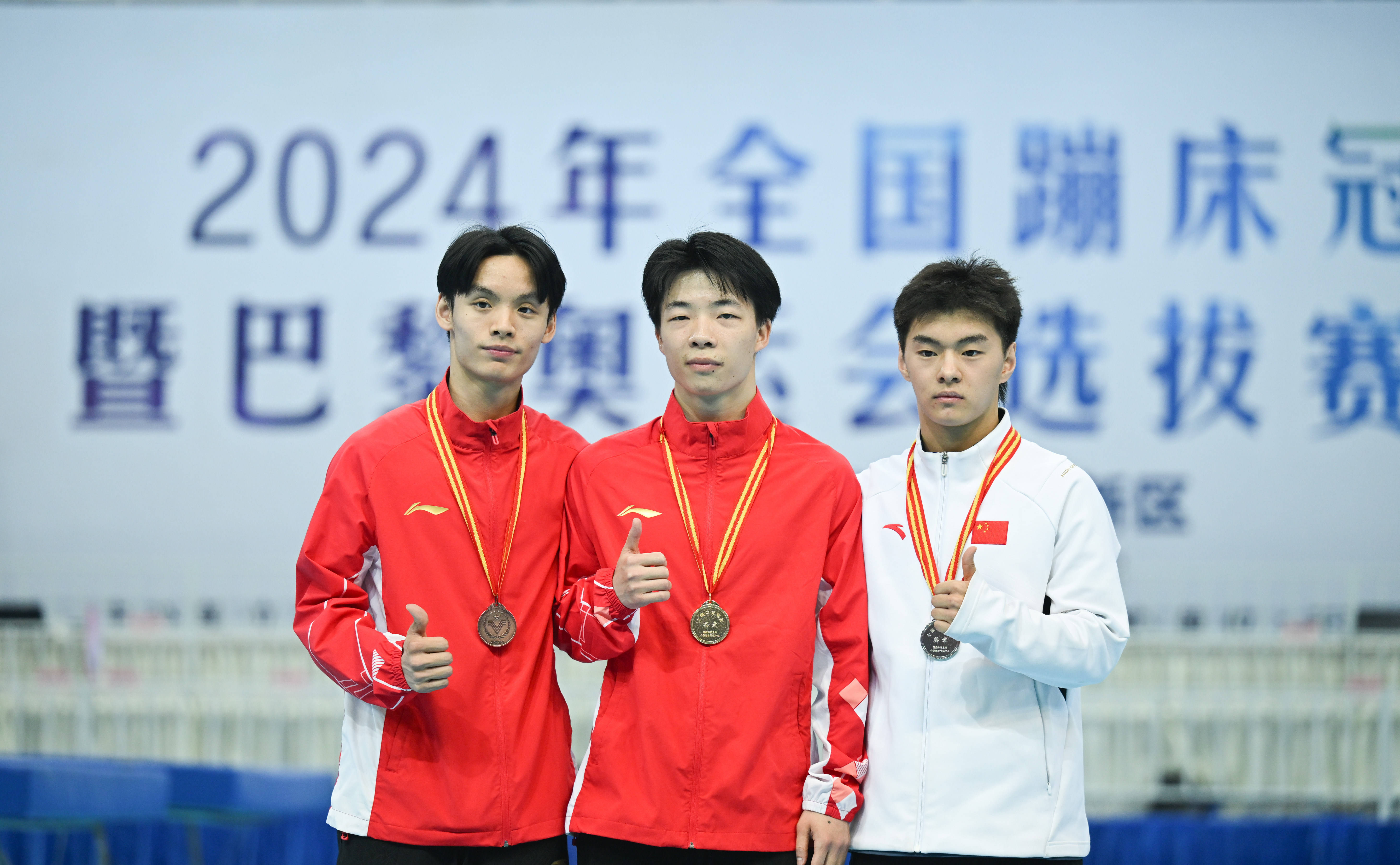 日,冠军湖南高速蹦床队选手严浪宇(中),亚军江苏蹦床队选手王梓赛(右)