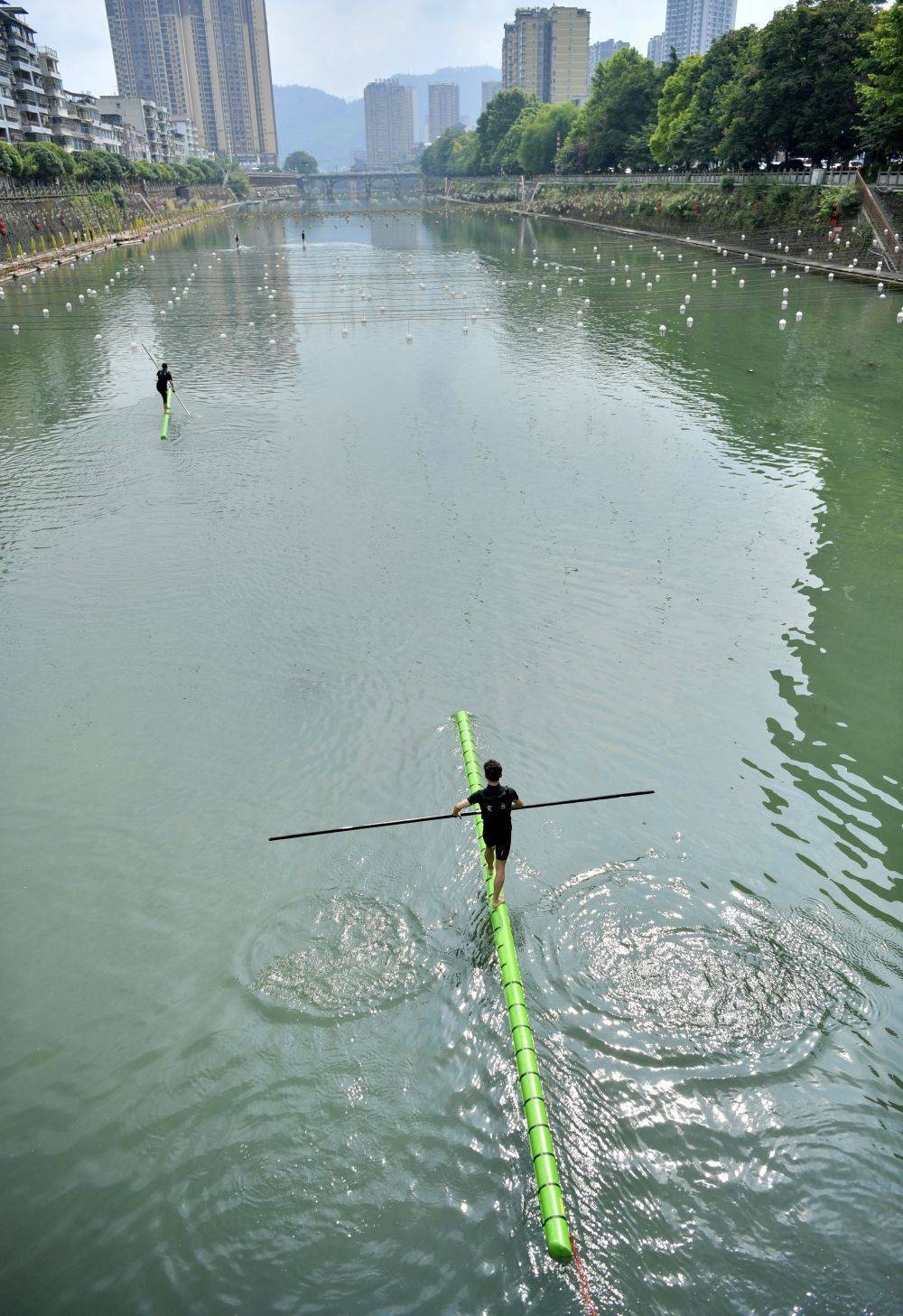 5月22日,水上运动爱好者在湖北省宣恩县城区的贡水河上展示"独竹漂".