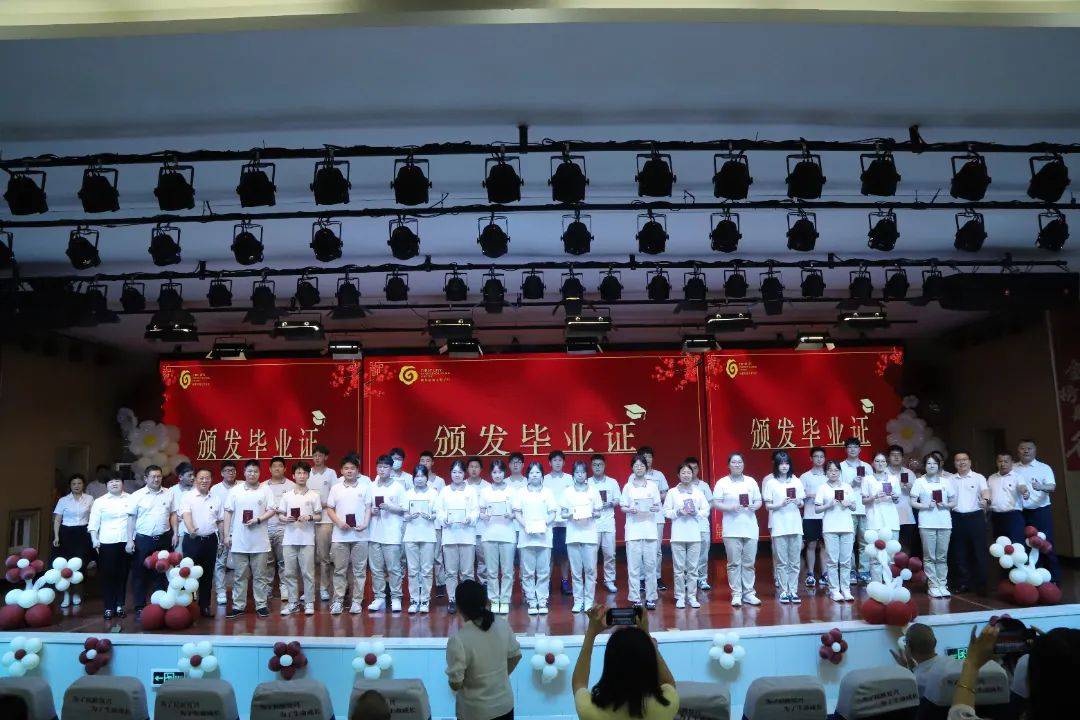 各班同学有序登台,学校领导为同学们一一颁发毕业证书.