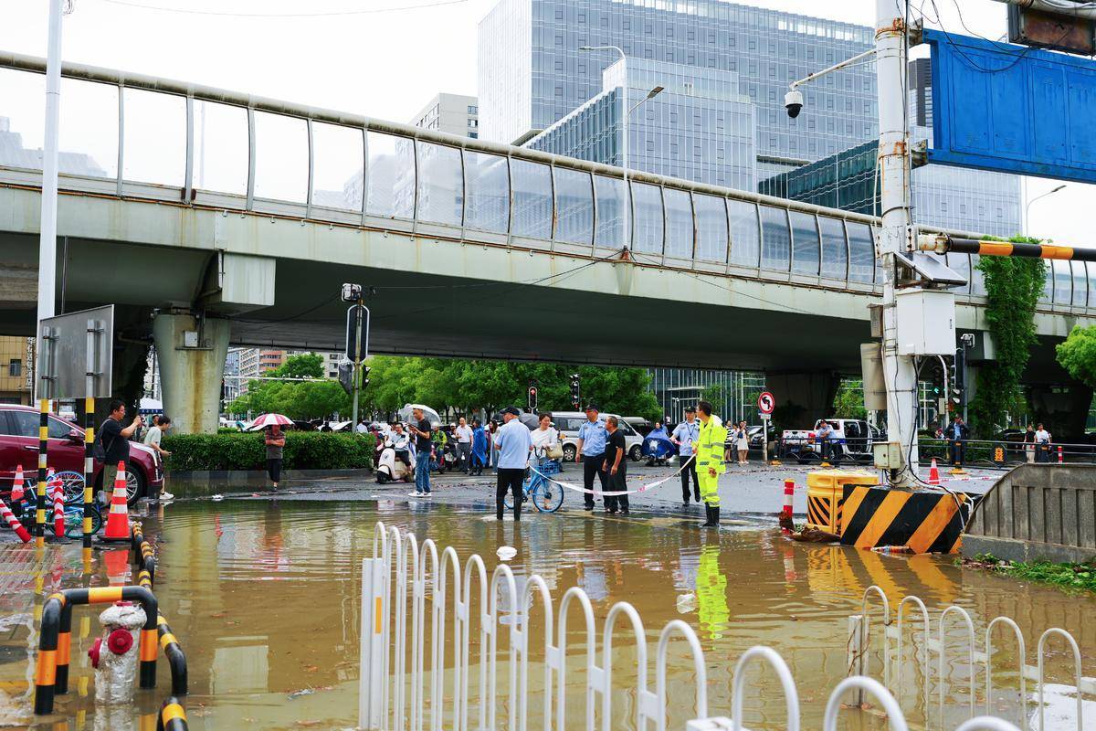 暴雨中的武汉大学珞珈门：家长互助趟渍水，城管拉绳筑 “安全线”_交通_高峰期_少哲