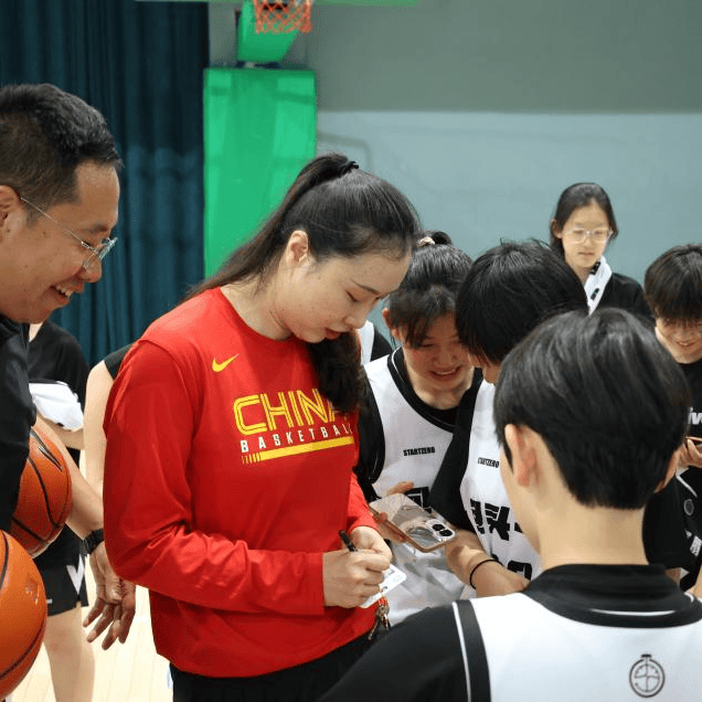 邵婷老师在包头一中篮球馆与校篮球队的同学们围在一起,展开了真诚而