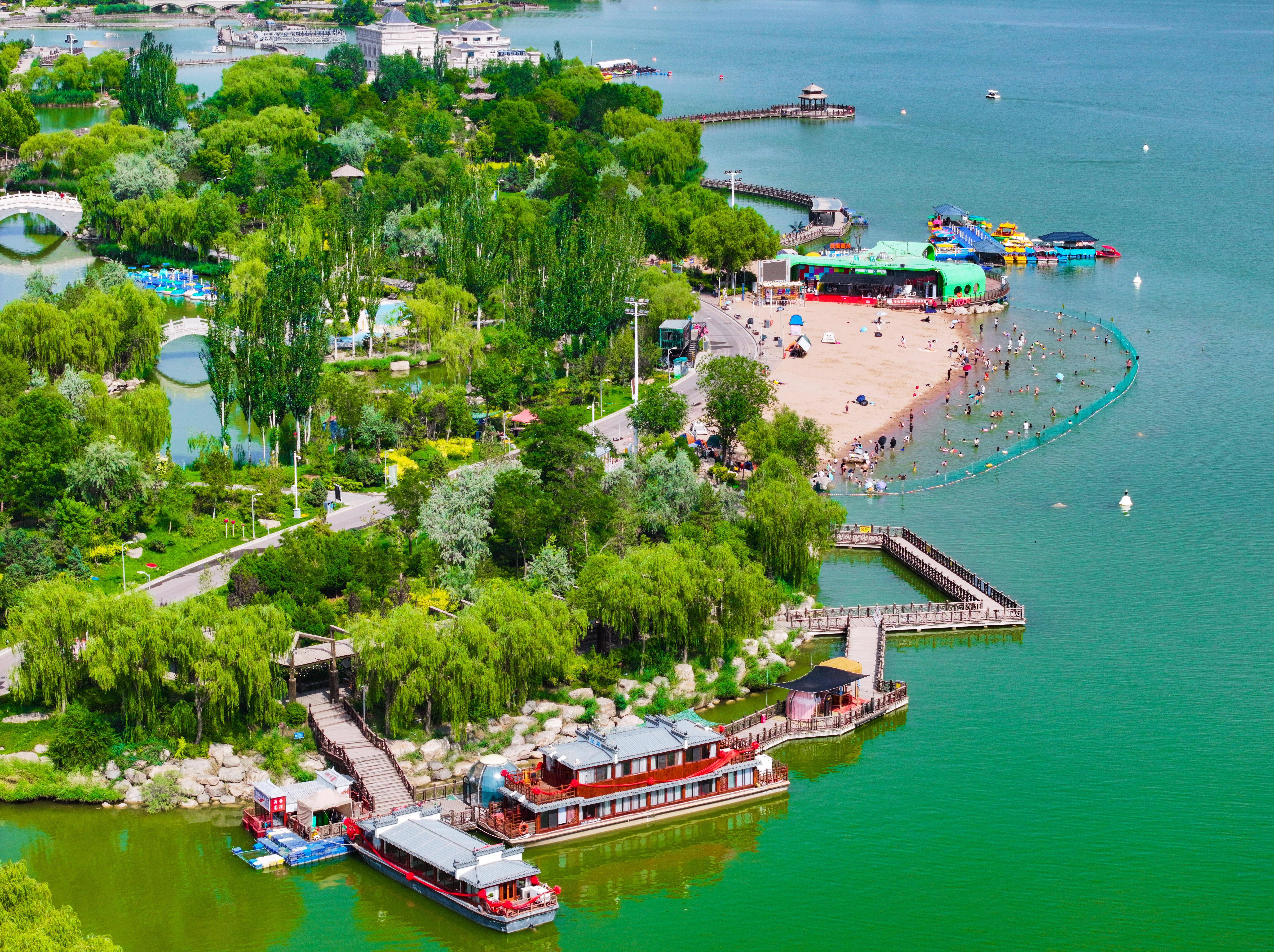 阅海湾水上公园以其广阔的沙滩和碧绿的水域成为避暑首选地