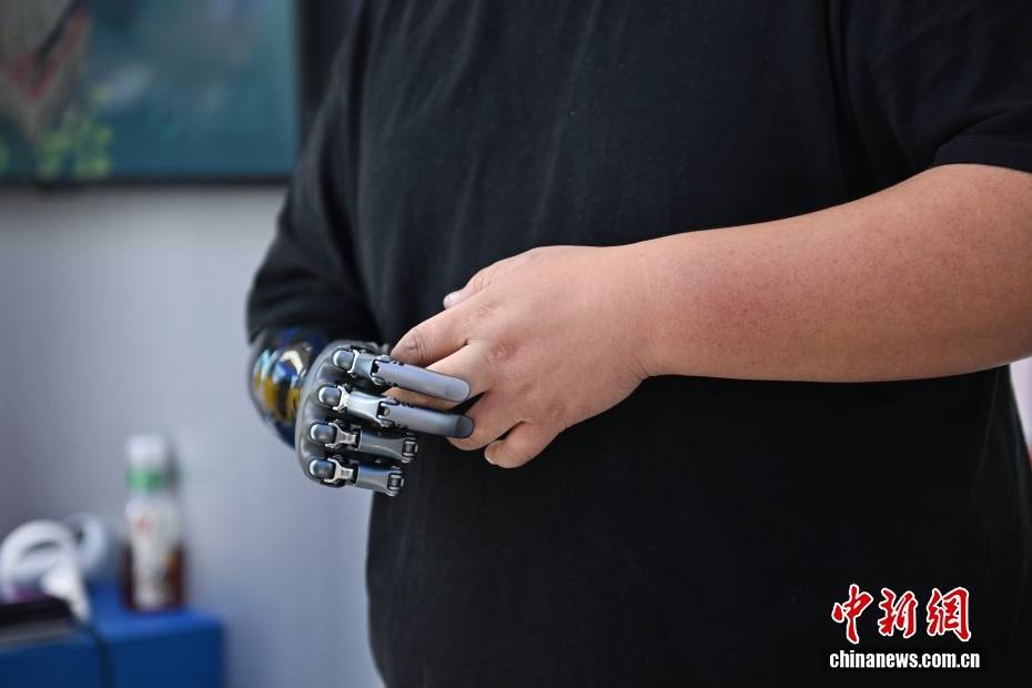 图为强脑科技工作人员佩戴的智能仿生手。中新网记者 李骏 摄图为机器人