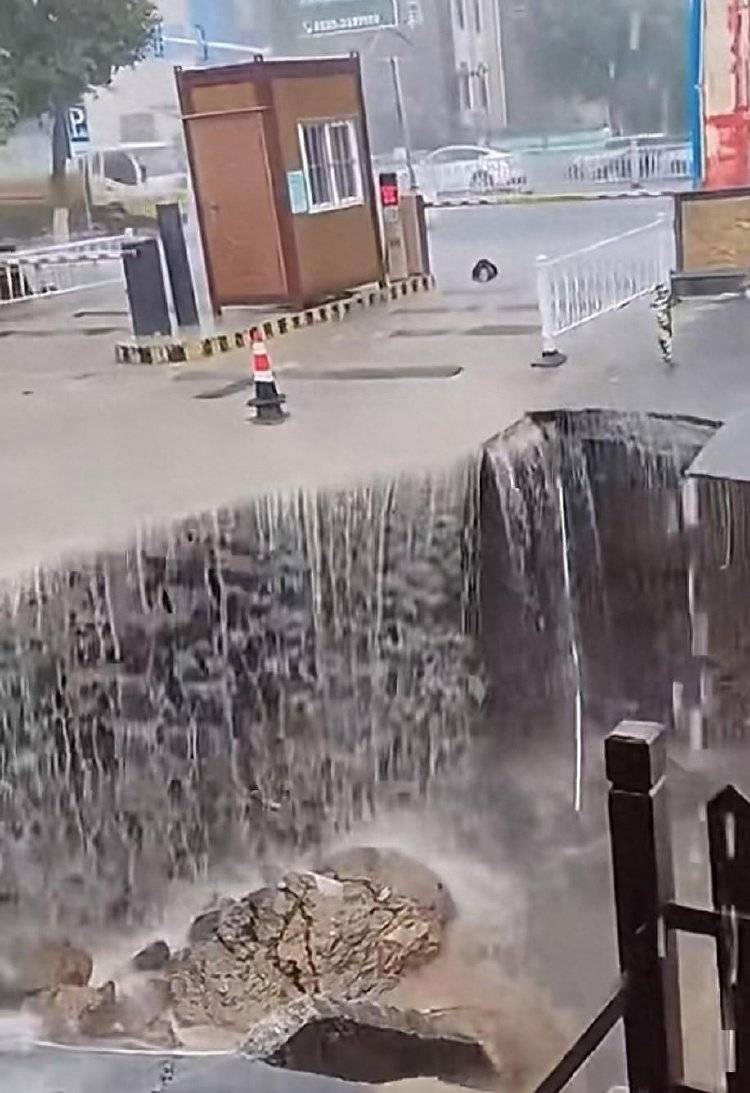 山东烟台遭暴雨突袭一道路发生塌陷，水流倾泻而下似“水帘洞”