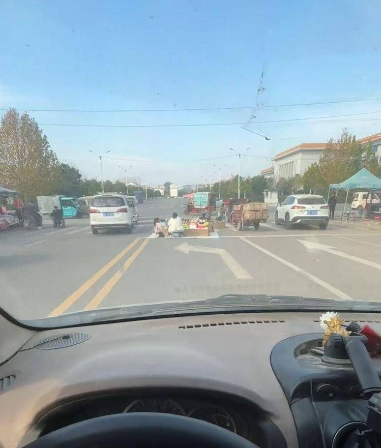 河南驻马店有人在斑马线摆摊，过路司机只能压双黄线绕行，民警：当天是集市，已前往劝导商户